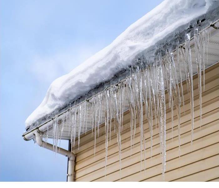 Icicles hanging from the roof, highlighting winter’s chill and potential hazards for your home.