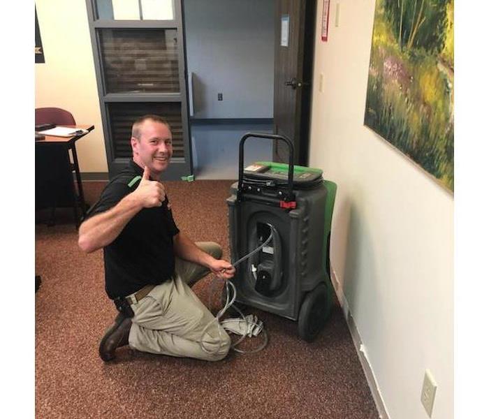 SERVPRO employee setting airmovers in a classroom 
