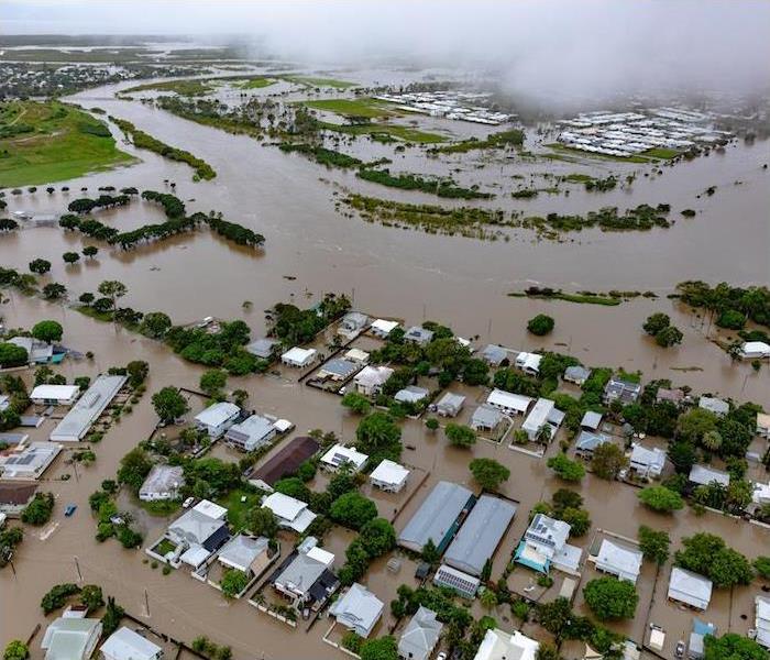 Severe flooding leaves homes and streets submerged in muddy water.