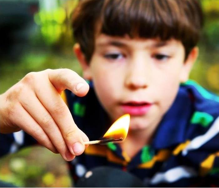img src =”fire” alt = " young boy staring at a lit match being held between his fingers” >